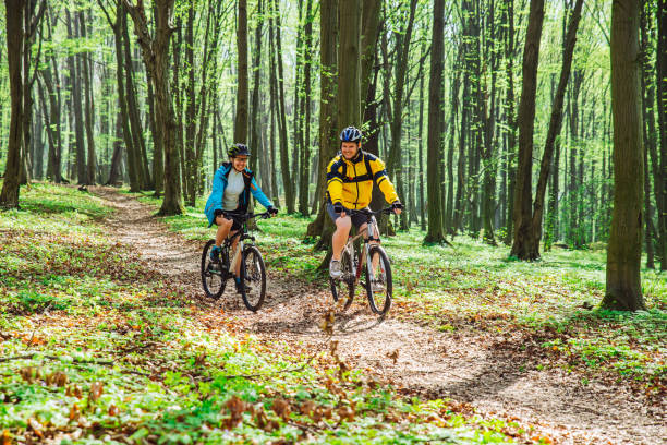 istock couple riding bicycle in forest in warm day 970405610