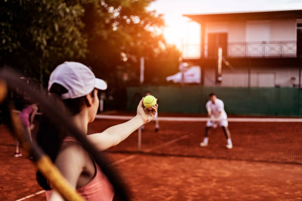 giocatore di doppio misto che gioca a tennis sul campo da tennis in terra battuta - doppio foto e immagini stock