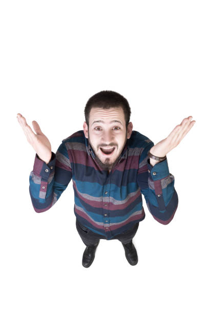 istock High angle view of surprised young man looking at camera by smiling over white background 970416572