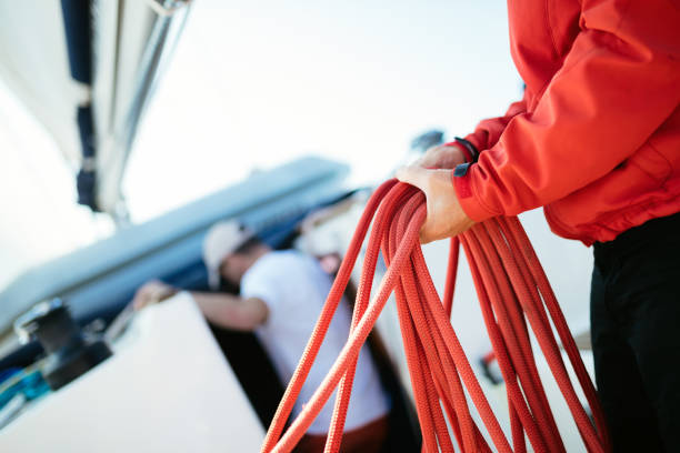 junge hübsche seemann segelboot seil ziehen - cable winch sailing yacht sport stock-fotos und bilder
