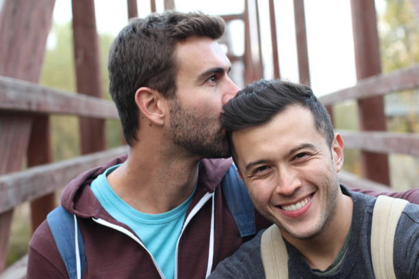 pareja gay disfrutando de una caminata - gay man homosexual men kissing fotografías e imágenes de stock