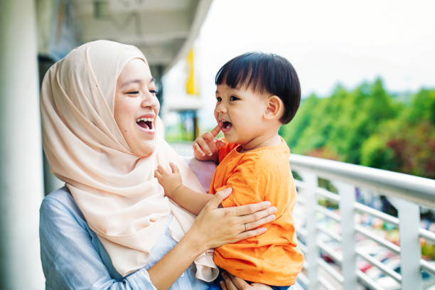 Muslim mother laughing with young son stock photo
