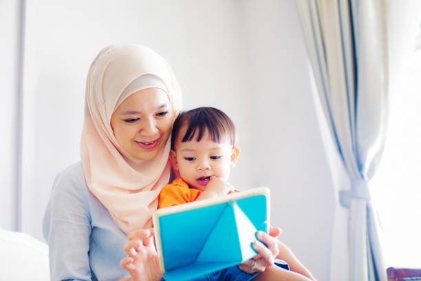 istock Mother plays media on tablet for her young son 970424386
