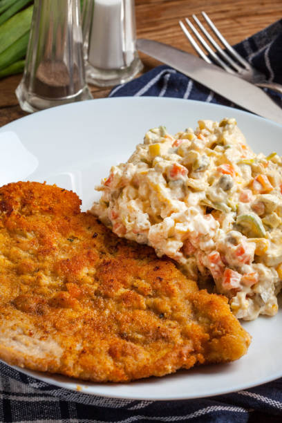istock Fried pork chop in breadcrumbs, served with vegetable salad. 970437510