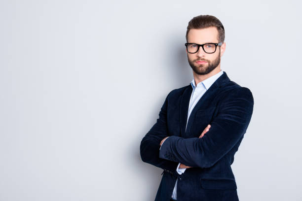 istock Portrait with copy space, empty place for advertisement of elegant half turned teacher with stubble having his arms crossed looking at camera isolated on grey background 970437612