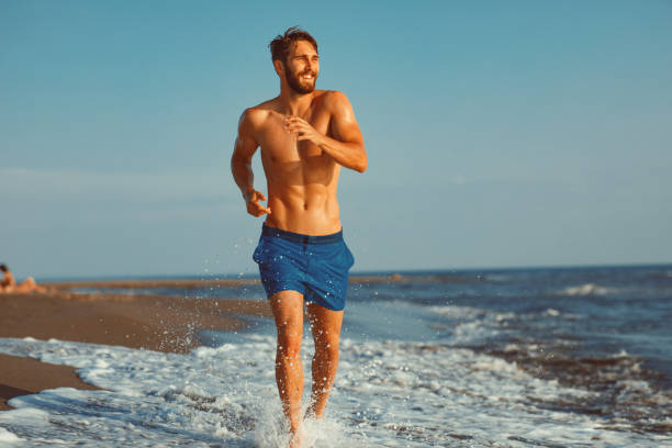 istock Handsome young man having fun on the beach by the sea 970459770