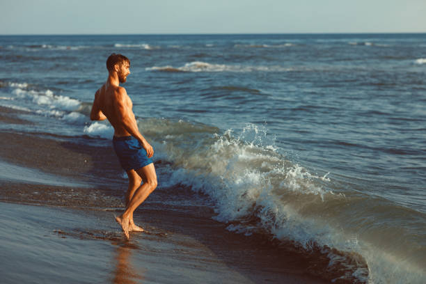 istock Handsome young man having fun on the beach by the sea 970470838