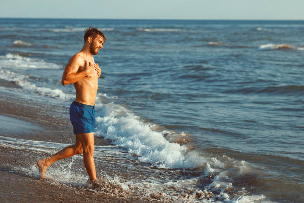 istock Handsome young man having fun on the beach by the sea 970471238
