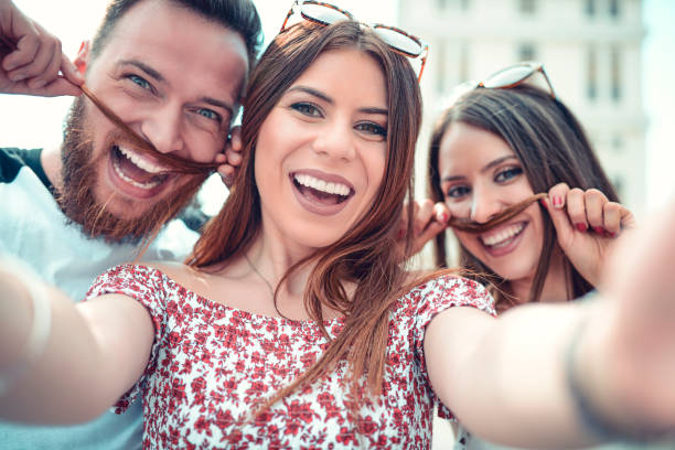istock Three Crazy Friends Making Fake Mustache With Hair On Selfie 970482354