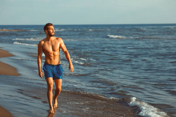 istock Handsome young man having fun on the beach by the sea 970484830