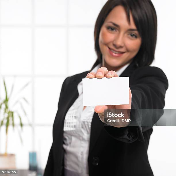 Mujer De Negocios Joven Sosteniendo Una Tarjeta De Negocios Vacía En Oficina Moderna Foto de stock y más banco de imágenes de Adulto