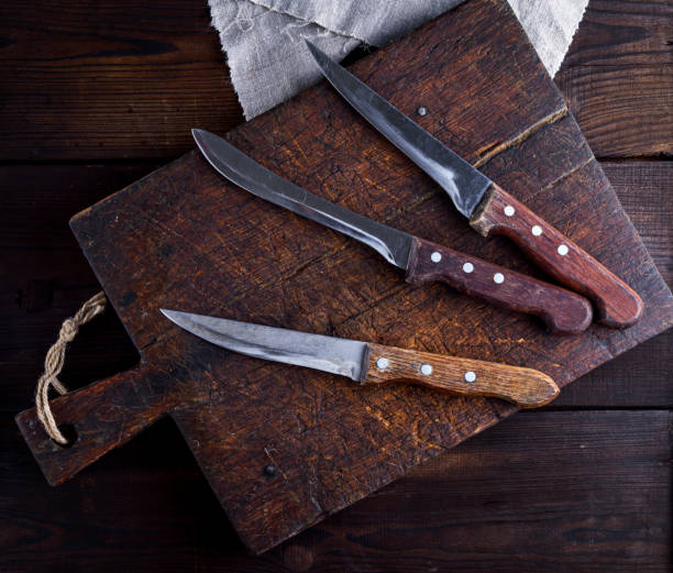 istock three old kitchen knives on a brown wooden cutting board 970489488