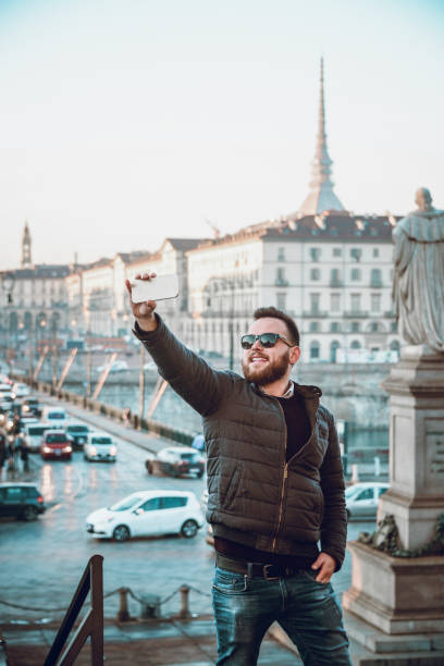 istock Handsome Male With Sunglasses Taking Selfie in Town Square 970489632