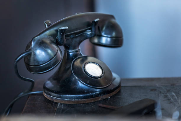 istock Vintage black telephone on old wood desk 970492786
