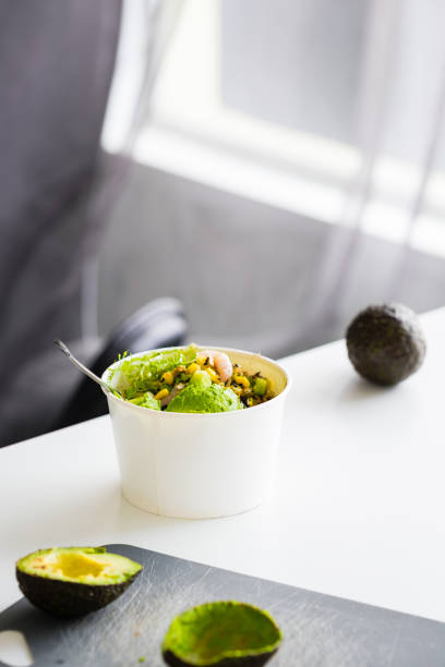 Green salad to go in white paper bowl