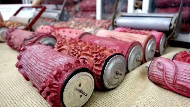 Vintage red rubber paint rollers with textured detail on a hessian cloth, at a market stall in Hungary