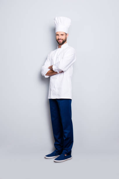 retrato de cuerpo completo tamaño del cocinero chef positiva alegre con rastrojo en beret, con sus brazos cruzados, aislado sobre fondo gris, mirando a cámara - shoe business expertise human resources fotografías e imágenes de stock