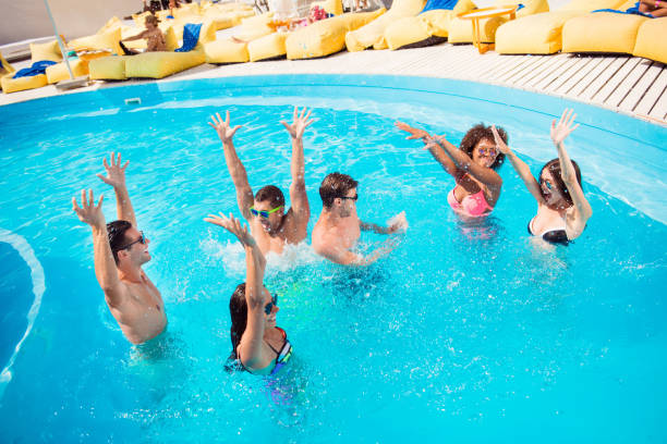istock Six friends making splashes in blue clear pool 970550270