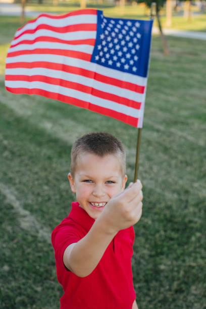 istock Young boy holding USA flag above his head 970589608