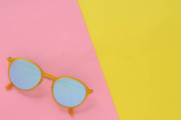 istock Yellow sunglasses on colorful background for summer time. 970596220