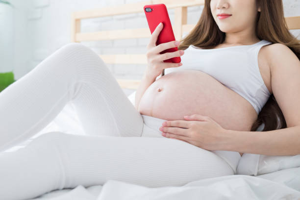 istock pregnant women use phone happily 970598380
