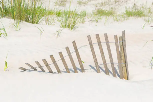 A fence buried in the sand on a beach in St. Augustine, Florida.