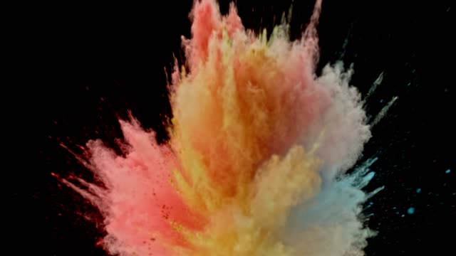 SLO MO Multi colored powder dust bursting into the air on black background and causing a cloud