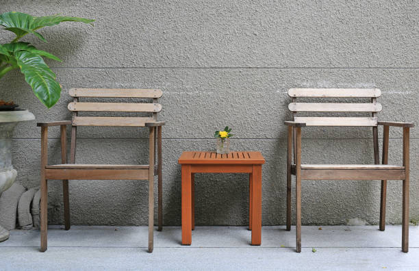 istock Wood chairs with mini wood table against rug cement wall. 970654568