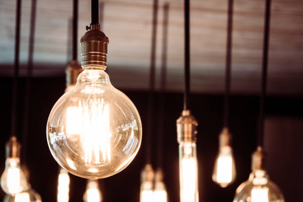 istock Close-Up Of Illuminated Light Bulbs Hanging At Night 970657994