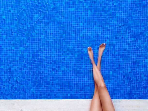 istock Female legs in the pool water 970675990