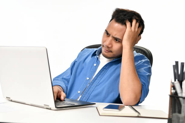 istock Casually-dressed startup business man holding his head looking stressed while working on a laptop 970689206