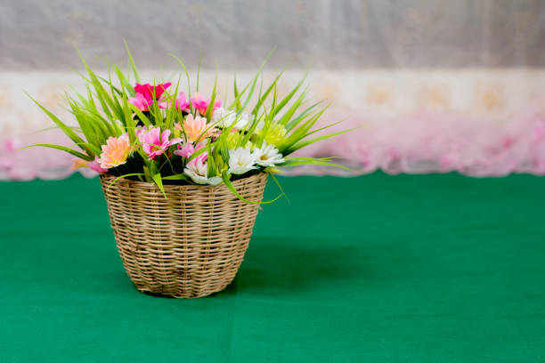 Artificial flower in wooden basket.