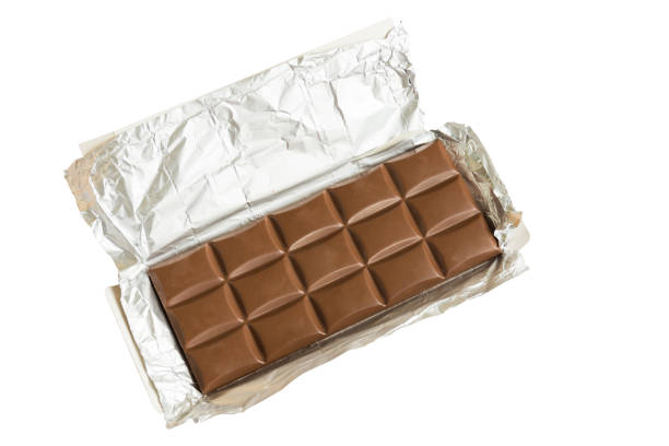 istock Tasty milk chocolate bar open in silver foil isolated on white background. 970729898