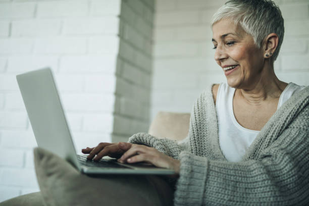 istock Happy senior woman typing an e-mail on laptop at home. 970732888