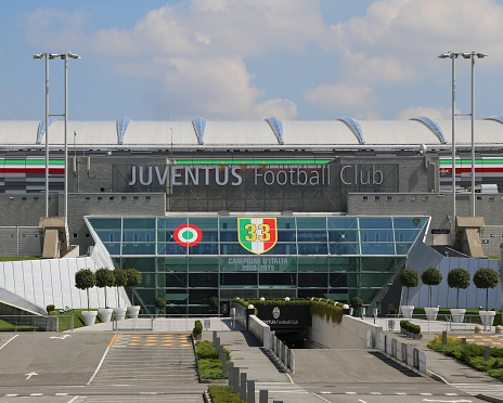 Turin, TO, Italy - August 27, 2015:Main gate of huge the Juventus Stadium with the name of the football club and the italian flag with number of cups