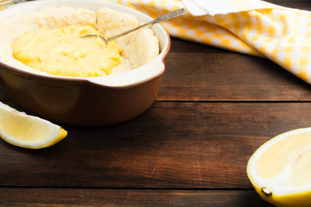 istock Preparation of cake with lemon curd over wooden table with copy space 970733764