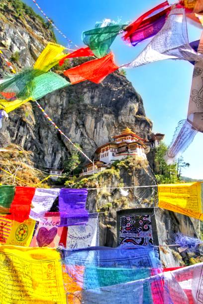 drapeaux de prières bouddhistes coloré au monastère de taktshang goemba ou du tigre nid à paro, bhoutan - monastère de taktsang photos et images de collection