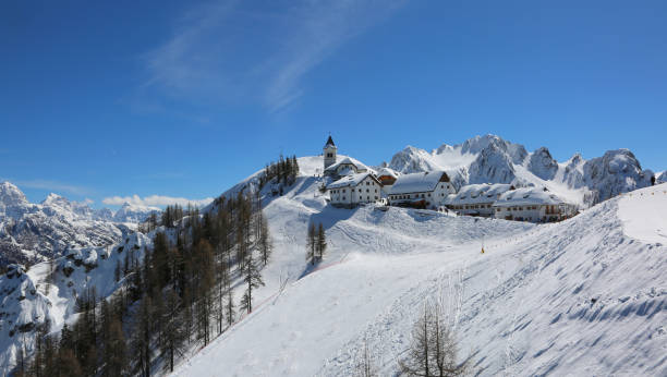 Lussari Mountain, UD, Italy - April 1, 2018: panoramic view of the ancient Sanctuary with snow and more buildings