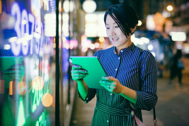 홍콩 금융 전에 태블릿에 주식 시장 데이터를 검사 하는 아시아 경제인 보드 표시 - hong kong night china asia 뉴스 사진 이미지