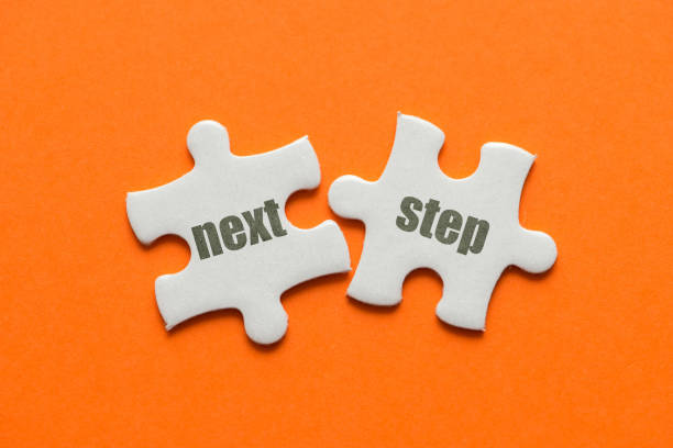 istock The word Next Step on two matching puzzle on orange background 970739492