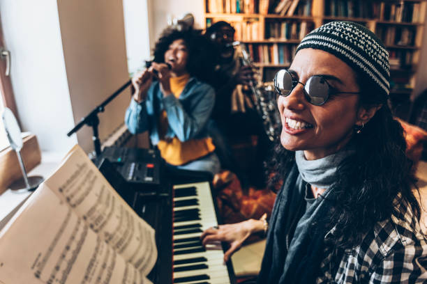 istock Young boho woman playing piano with friends 970740506
