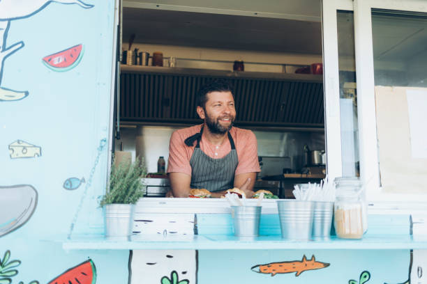 istock Smiling man standing inside of a food van 970740854
