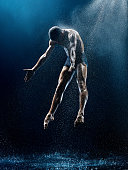 istock Athletic ballet dancer performing with water 970757606