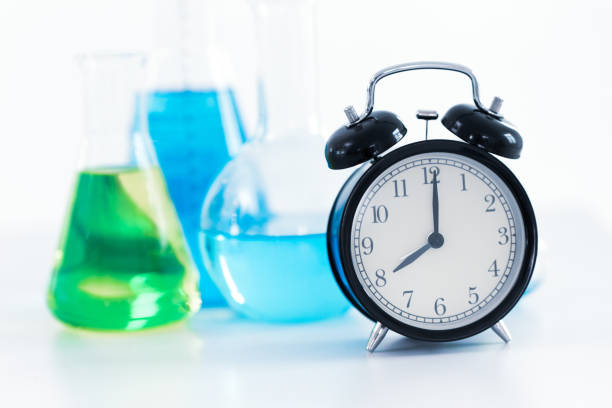 istock 8 o'clock retro clock with Science Chemical medical research lab background 970761246