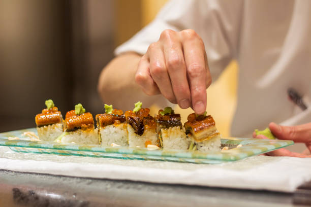 chef de sushi prépare des repas japonais pour les clients dans un restaurant - sushi styles photos et images de collection