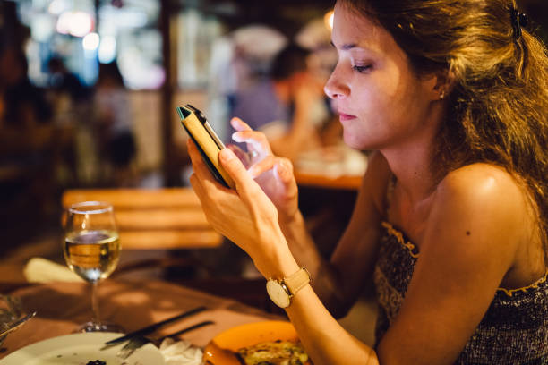 istock Woman having dinner in restaurant and text messaging 970774680