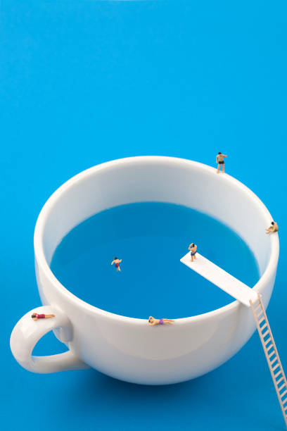 istock miniature people in mug cup swimming pool 970775766