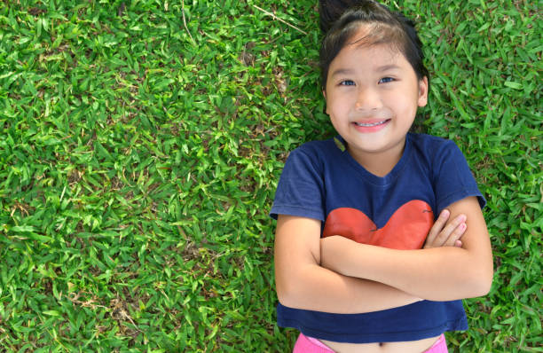 istock cute girl smile and lie down on grass 970778250