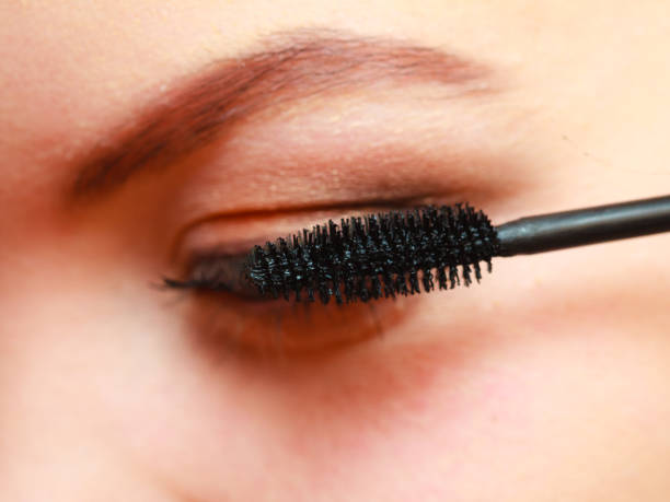 istock Close up woman getting make up, mascara 970784946