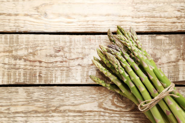 istock Bunch of green asparagus on grey wooden table 970787940
